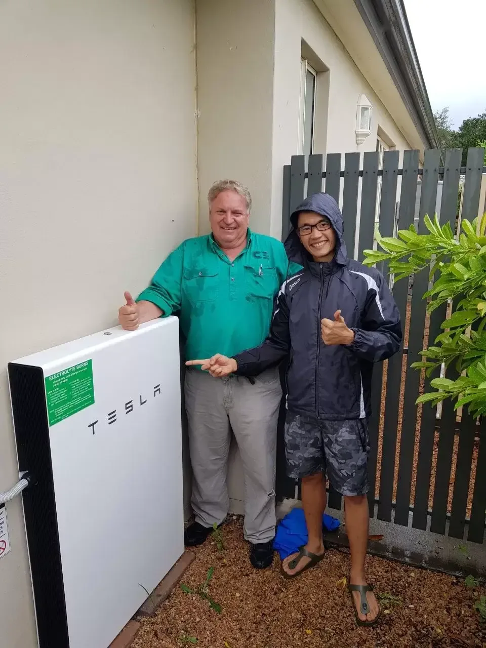 Home battery system beside two people